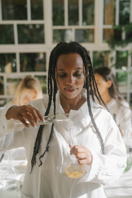 All Courses African American woman in a laboratory pouring liquid for an experiment.